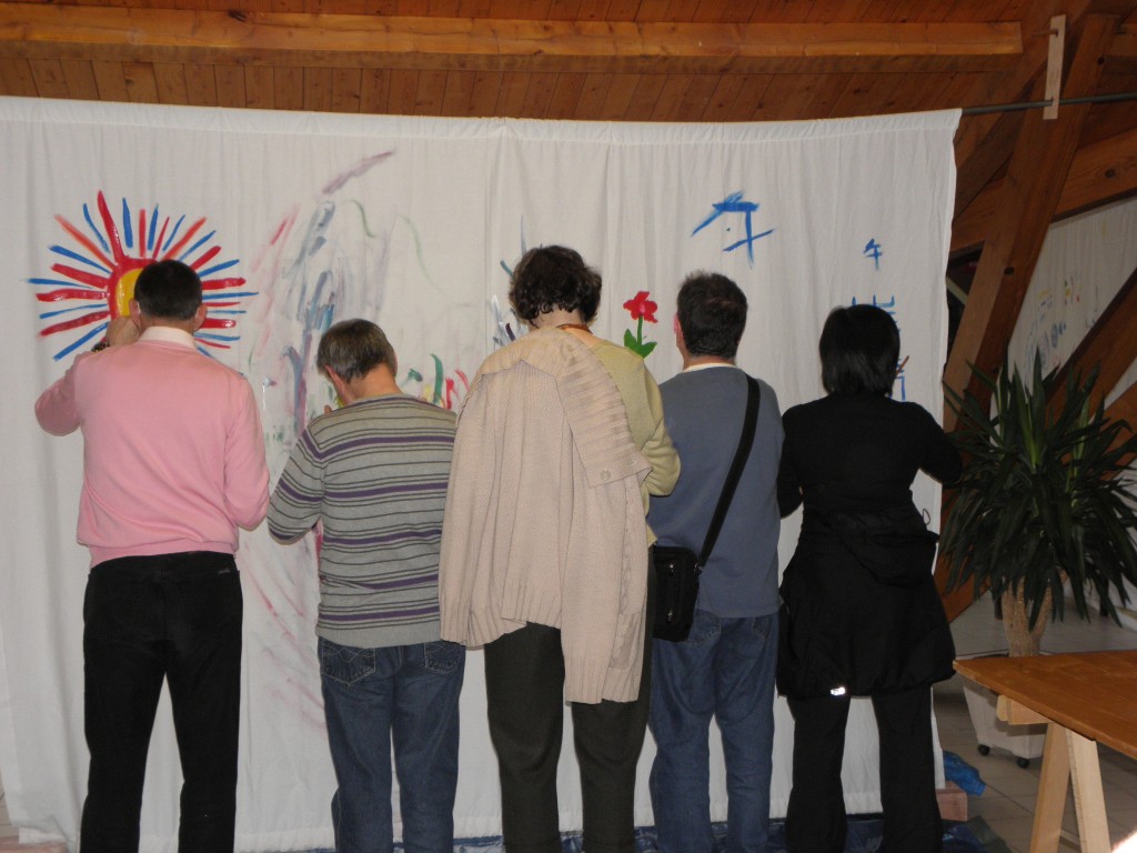 Pause Arc en ciel des 10èmes Journées Voix : 5 personnages de dos dessinent sur un même grand drap